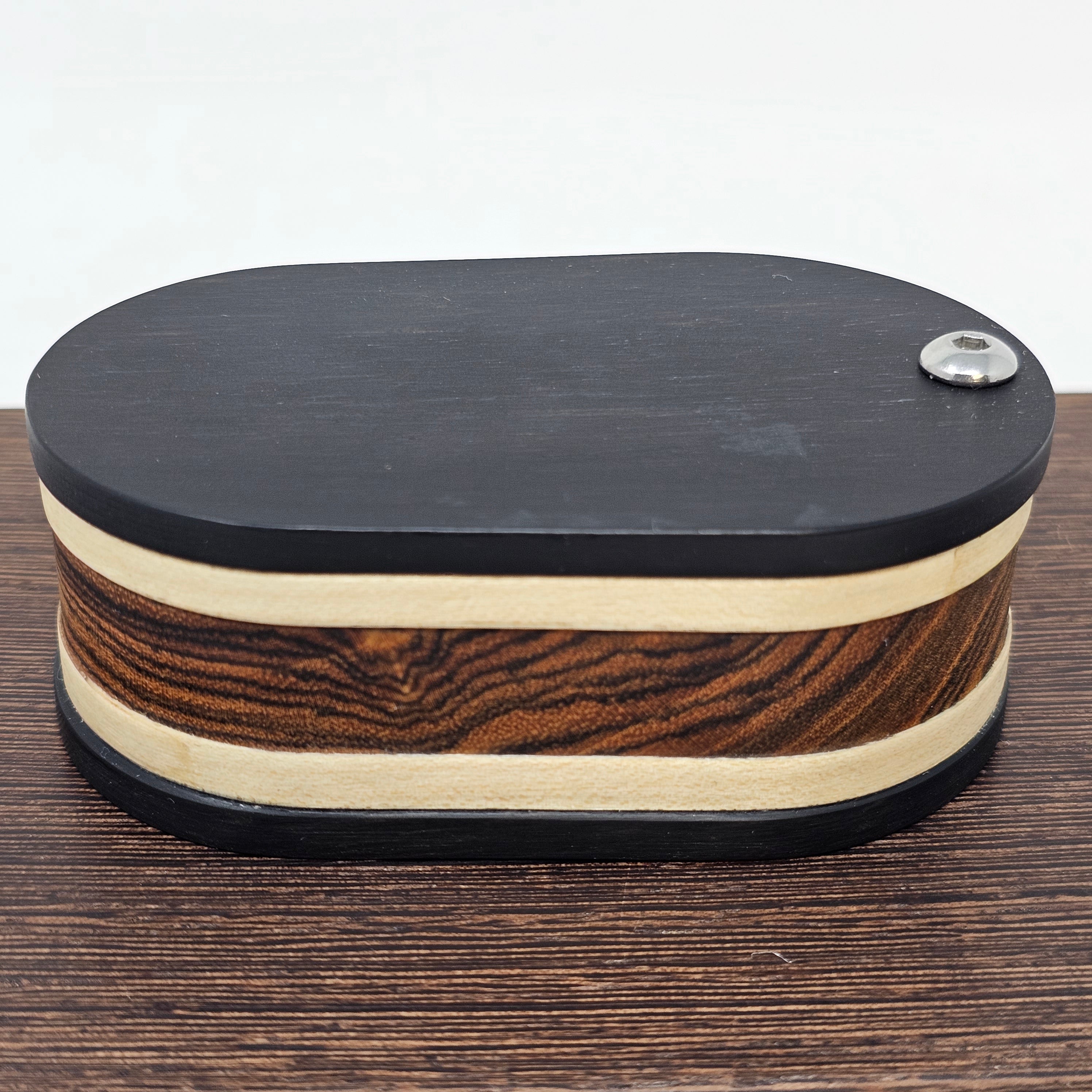 Vapman Case in Bocote/Sycamore/Ebony.

Handcrafted in the United Kingdom by PhattPiggie.

You are purchasing one Vapman case. No Vapman unit is included. One is shown for demonstration purposes only. Case operates with a rotating magnetic lid.