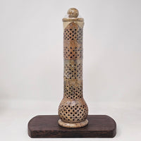 A beige soapstone incense burner with geometric cut-outs and patterns