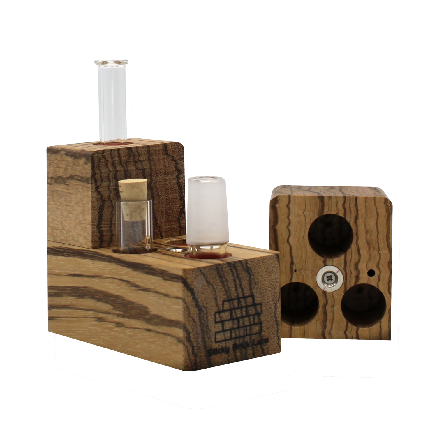 The Sticky Brick Maxx is available in a variety of wood choices. Ships with a torch, 18mm female, 18mm male, and 14mm male whip connectors along with 16” of silicone whip tubing, 18mm female dry mouthpiece, 6-pack of screens, carb corks, an extra jar cork, and led tweezers. Now ships with two Restrictor Discs.